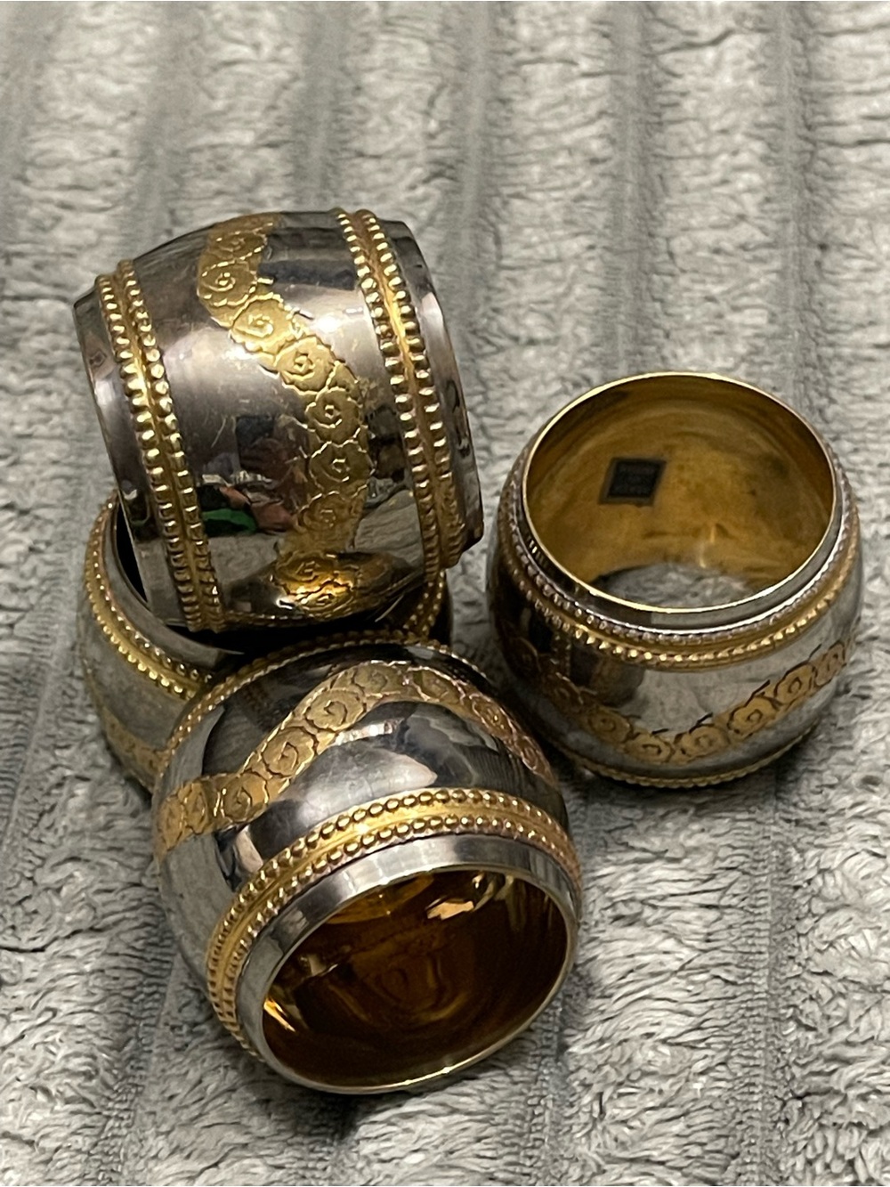 Set of four silver and gold napkin rings